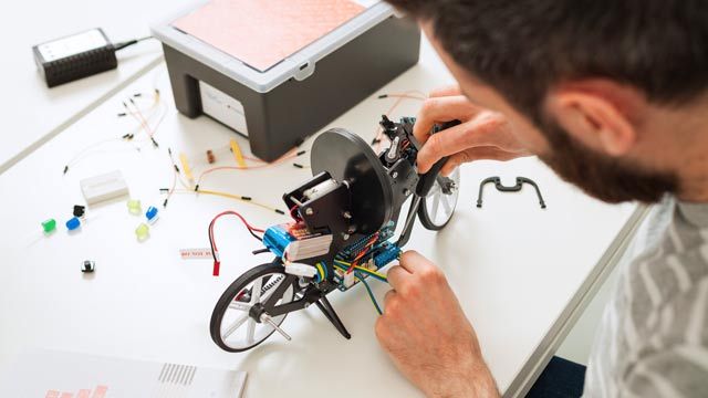 Arduino Kit 低価格ハードウェアで作業する学生。